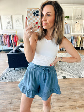 Flavia Ruffle Tiered Denim Shorts - Light Denim-BottomsFlavia Ruffle tiered Denim Shorts - Light Denim | VerClare Boutique | Jenison MI -Ruffle Tiered Denim Shorts are a beautiful soft denim woven ruffle-tiered short featuring a playful tiered ruffle design, a comfortable drawstring waistband, and a relaxed, feminine silhouette. Free US shipping from VerClare Boutique.-VerClare Boutique