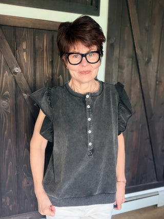 Zella Raw Edge Flutter Sleeve Top - Black-Tops Basic SolidZella Raw Edge Flutter Sleeve Top - Black | VerClare Boutique | Jenison MI -Raw Edge Flutter Sleeve Top is a beautiful soft washed cotton-blend knit button-front top featuring feminine flutter sleeves, raw cut edge detailing, and a relaxed, easy silhouette. Free US shipping on eligible orders. -VerClare Boutique