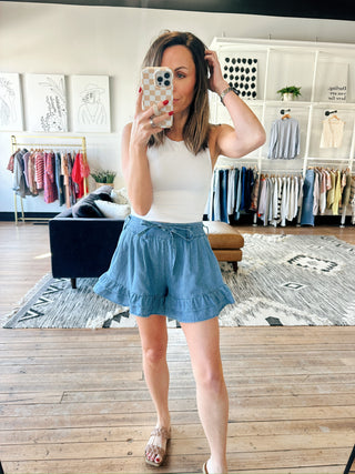 Flavia Ruffle Tiered Denim Shorts - Light Denim-BottomsFlavia Ruffle tiered Denim Shorts - Light Denim | VerClare Boutique | Jenison MI -Ruffle Tiered Denim Shorts are a beautiful soft denim woven ruffle-tiered short featuring a playful tiered ruffle design, a comfortable drawstring waistband, and a relaxed, feminine silhouette. Free US shipping from VerClare Boutique.-VerClare Boutique