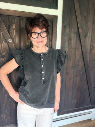 Zella Raw Edge Flutter Sleeve Top - Black-Tops Basic SolidZella Raw Edge Flutter Sleeve Top - Black | VerClare Boutique | Jenison MI -Raw Edge Flutter Sleeve Top is a beautiful soft washed cotton-blend knit button-front top featuring feminine flutter sleeves, raw cut edge detailing, and a relaxed, easy silhouette. Free US shipping on eligible orders. -VerClare Boutique