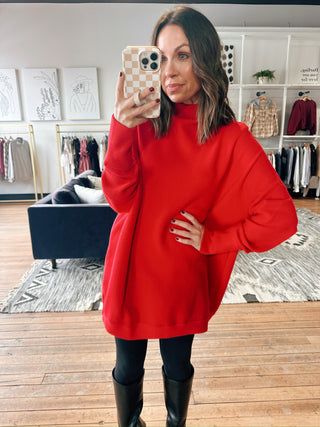 Woman wearing a red sweater in a clothing store