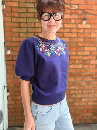 Scarlette Multi Color Embroidery Top - Navy-Tops Basic SolidVOY Scarlette Multi Color Embroidery Top - Navy | VerClare Boutique-Shop the VOY Scarlette Multi Color Embroidery Top in Navy. Soft knit, multicolor floral embroidery, scallop trim, round neck, feminine silhouette. Sizes S–L.-VerClare Boutique