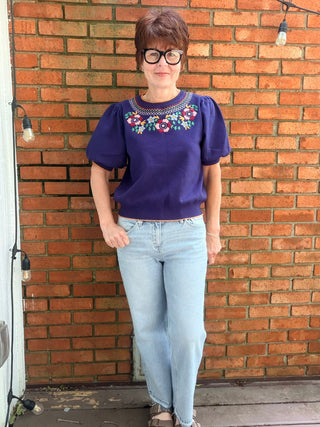 Scarlette Multi Color Embroidery Top - Navy-Tops Basic SolidVOY Scarlette Multi Color Embroidery Top - Navy | VerClare Boutique-Shop the VOY Scarlette Multi Color Embroidery Top in Navy. Soft knit, multicolor floral embroidery, scallop trim, round neck, feminine silhouette. Sizes S–L.-VerClare Boutique