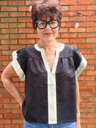 Amina Flutter Sleeve V-Neck Top - Black-Tops CasualAmina Flutter Sleeve V-Neck Top – Black | THML – VerClare Boutique-Shop the THML Amina Flutter Sleeve V-Neck Top in Black. Linen-viscose blend, flutter sleeves, contrast trim, V-neck, true-to-size fit. Sizes XS–L.-VerClare Boutique