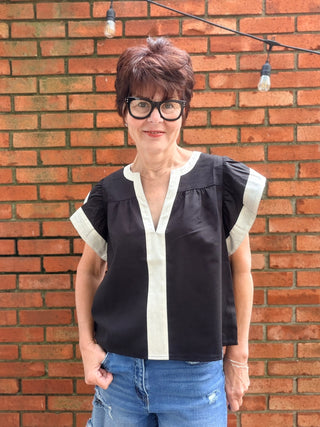 Amina Flutter Sleeve V-Neck Top - Black-Tops CasualAmina Flutter Sleeve V-Neck Top – Black | THML – VerClare Boutique-Shop the THML Amina Flutter Sleeve V-Neck Top in Black. Linen-viscose blend, flutter sleeves, contrast trim, V-neck, true-to-size fit. Sizes XS–L.-VerClare Boutique